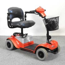 An orange Kymco electric mobility scooter, with charger