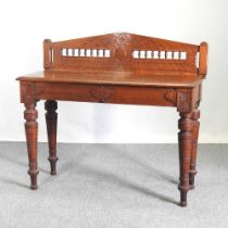 An Edwardian oak side table, with a gallery back, on turned legs 121w x 44d x 110h cm