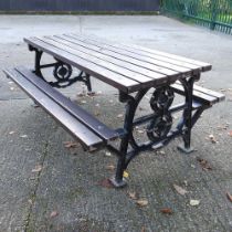 A large cast iron garden bench, with a McDonalds logo to the side 182w x 129d x 77h cm