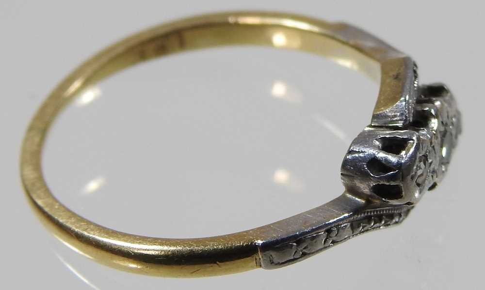 An 18 carat gold and platinum set three stone diamond ring, of crossover design, with textured - Image 2 of 5