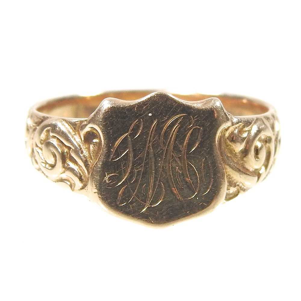 A 9 carat gold signet ring, the central shield engraved with initials, flanked by scrolled
