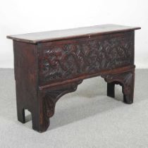 An 18th century and later carved oak six plank coffer, with a hinged lid, having Tudor rose and