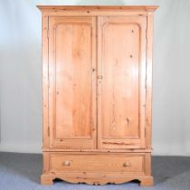 A pine double wardrobe, with a moulded cornice and single drawer below 132w x 59d x 200h cm