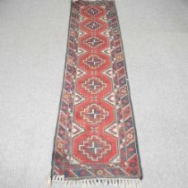 A Turkish runner, with a row of central medallions, 290 x 74cm