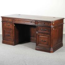 A modern oak pedestal desk, on a plinth base 167w x 77d x 79h cm