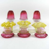 A set of three cranberry glass shades, the base stamped for Clarkes Patent Fairy night lights,