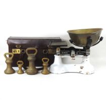 A set of kitchen scales, together with a collection of early 20th century brass weights, fitted in a