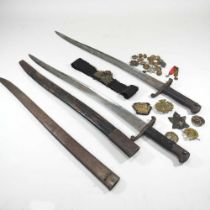 A British 1856 pattern sword bayonet, 73cm long, together with another and various military badges