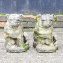 A pair of cast stone garden statues of seated dogs, 35cm high (2)