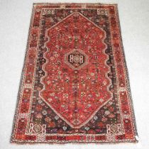 A Persian qashqai carpet, with all over designs and a central red medallion, 260 x 168cm