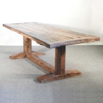 An antique refectory dining table, made from reclaimed tudor beams, with a plank top, on a trestle