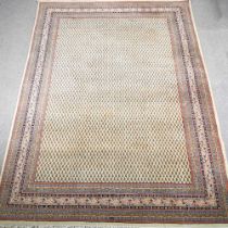 A large woollen carpet, with an all over design, on a cream ground, within multiple borders, 350 x