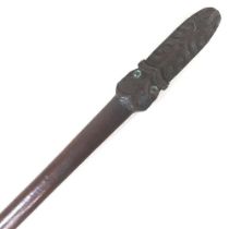 A New Zealand Maori carved hardwood Taiaka fighting staff, the terminal carved with a mask and