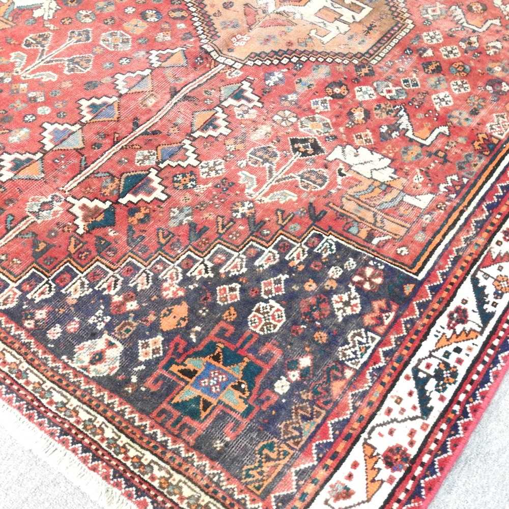 A Persian rug, with a central hooked medallion, on a red ground, 200 x 145cm - Image 2 of 5