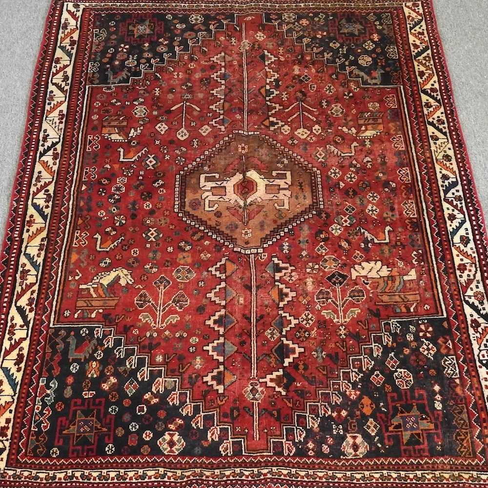 A Persian rug, with a central hooked medallion, on a red ground, 200 x 145cm