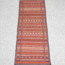 A Persian kilim, with rows of geometric designs, on a red ground, 200 x 75cm