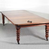 A large Victorian walnut wind out extending dining table, with three additional leaves, on