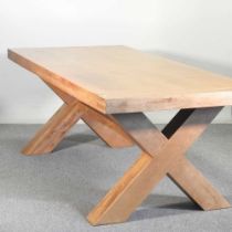 A modern light oak dining table, on an x-frame base 220w x 100d x 83h cm