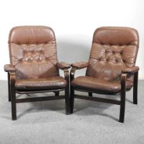 A pair of mid 20th century brown leather upholstered lounge chairs, with loose cushions