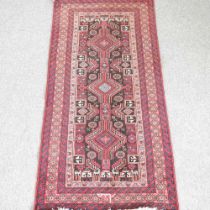A Persian rug, with a row of three central medallions, 190 x 85cm