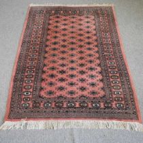 A bokhara rug, with two rows of medallions, on a red ground 194w x 124d cm