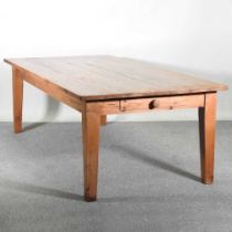 A large pine dining table, with a plank top, containing a frieze drawer, on square legs 244w x