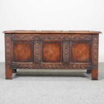 An antique carved oak and inlaid coffer, with a hinged lid, on stile feet 106w x 43d x 54h cm