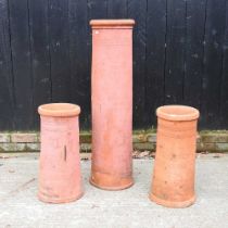 A pair of terracotta chimney pots, together with another larger, 110cm high (3)