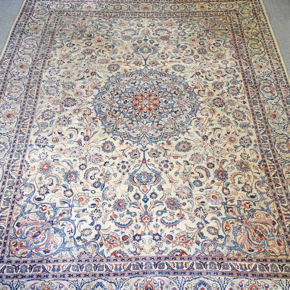 A large Persian woollen carpet, with all over foliate designs, on a cream ground, 395 x 305cm