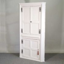An 18th century and later white painted standing corner cabinet, with a barrel back 103w x 199h cm
