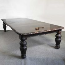 A very large 19th century carved dark oak wind-out extending dining table, on heavily carved legs,