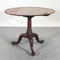 An early 20th century occasional table, with a hinged piecrust top, on a carved tripod base 89w x