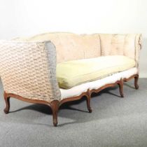 An early 20th century French upholstered canape sofa, with a buttoned back, on carved cabriole