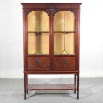 An Edwardian glazed display cabinet, on square legs, united by an undertier 109w x 38d x 175h cm