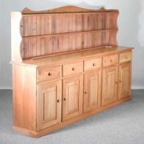 A handmade light ash dresser base, of large proportions, fitted with cupboards and drawers, with a