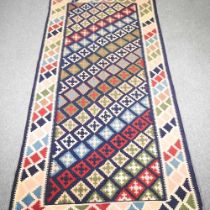 A Persian kilim, with diagonal rows of coloured diamonds, 275 x 150cm