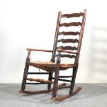 A 19th century elm and ash ladderback rocking chair, with a rush seat