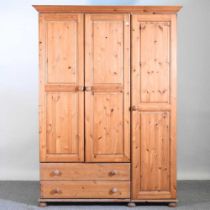 A modern pine triple wardrobe, with drawers below 138w x 56d x 188h cm
