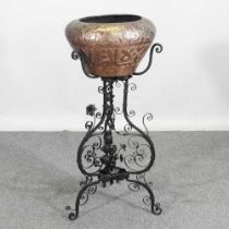 An Eastern copper jardiniere, on a wrought iron stand, 93cm high overall