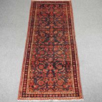 A Persian malayer runner, with all over foliate design, on a dark ground, 290 x 110cm