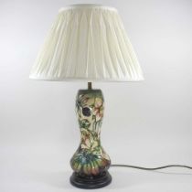 A Moorcroft pottery table lamp, decorated in the Hellebore pattern, by Nicola Slaney, with a cream