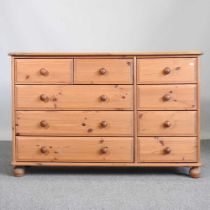 A modern pine chest, containing an arrangement of nine drawers 124w x 42d x 80h cm