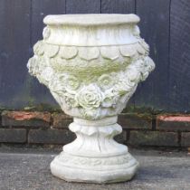 A cast stone garden urn, decorated with festoons, 61cm high