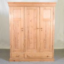 A pine triple wardrobe, with two drawers below 158w x 64d x 201h cm