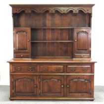 An 18th century style oak dresser, 20th century, with a boarded back, fitted with cupboards below