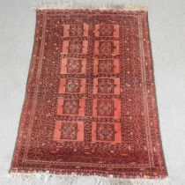 An Afghan woollen rug, with two rows of medallions, on a red ground, 200 x 122cm