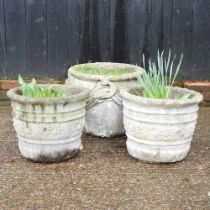 A cast stone garden pot, 37cm high, together with two others smaller (3)