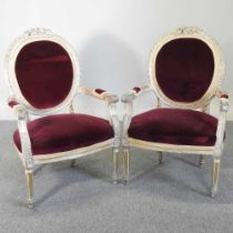 A pair of French style carved and gilt painted open armchairs, 20th century, upholstered in red,