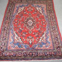 A Hamadan carpet, with a central medallion, on a red ground, 213 x 310cm