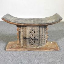 An early 20th century African Ashanti carved hardwood stool/head rest, with a dished seat 52w x